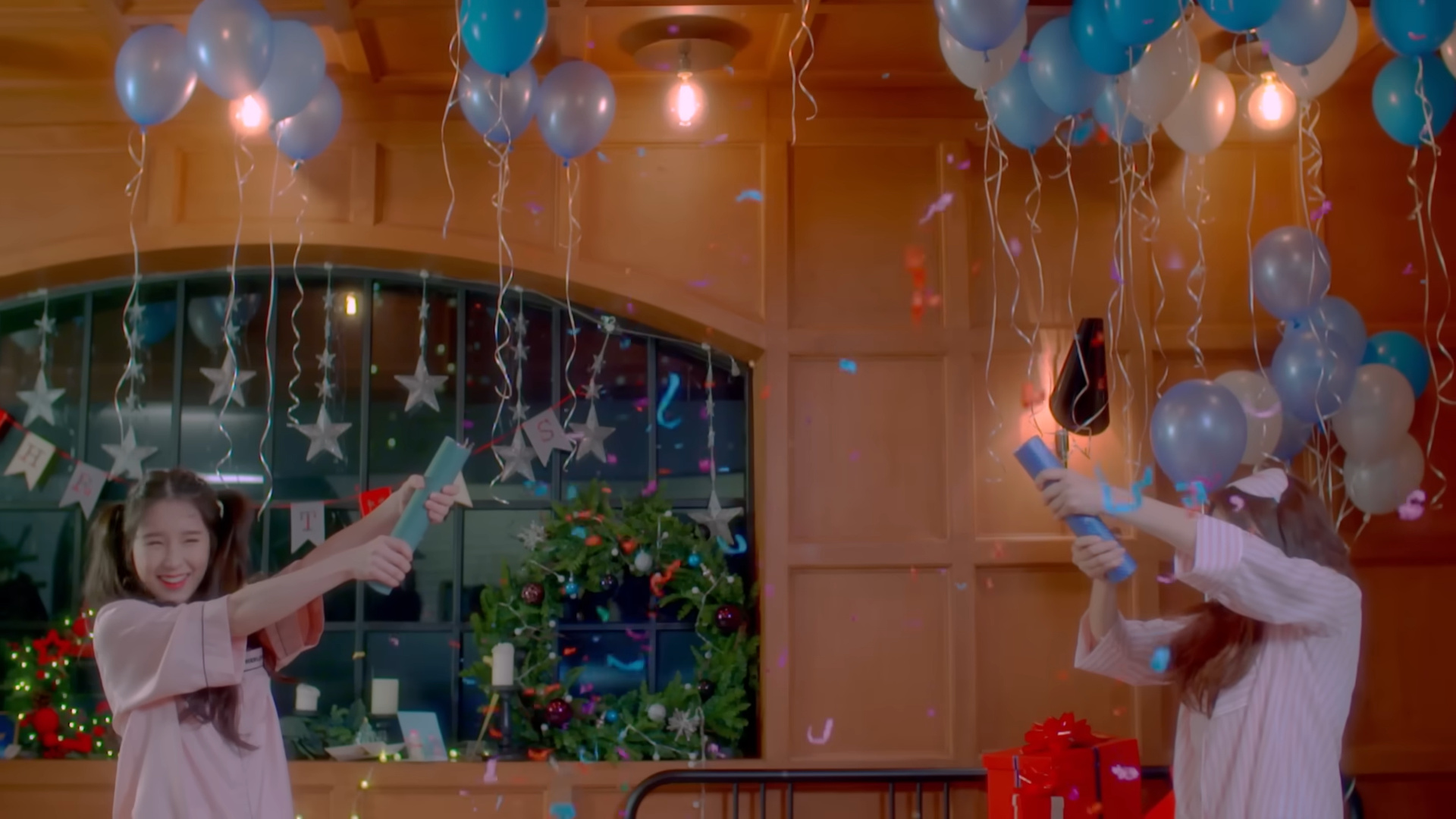 Heejin and Haseul firing confetti out of party poppers.
